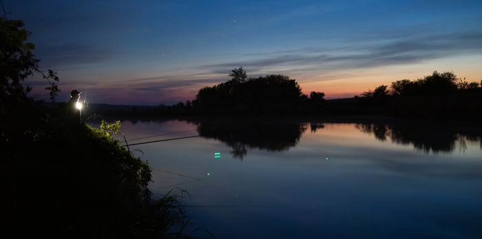 Man catching big bass at night