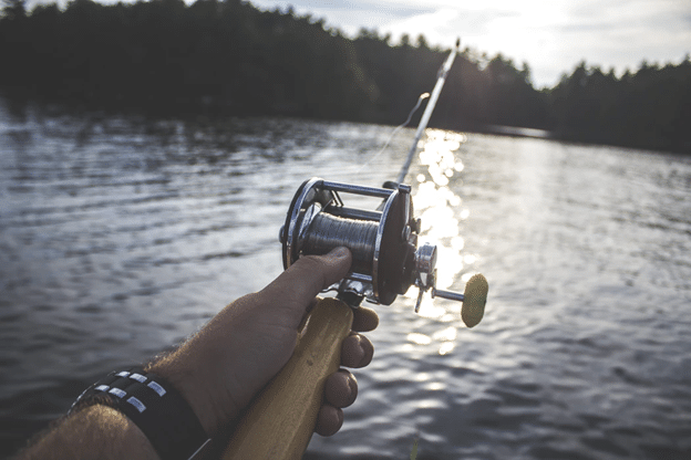 Casting reel on a lake in the summer